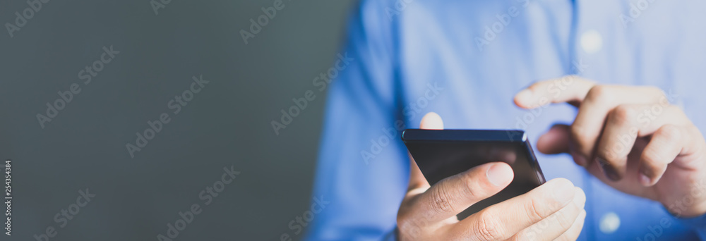 Wall mural man using mobile phone with copy space