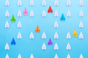 Group of paper planes in one direction and with one group individual pointing in the different way....