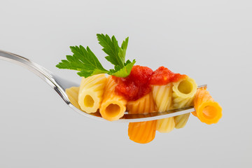 pasta on a fork with tomato sauce and parsley