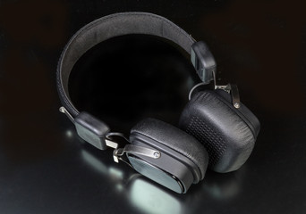 Fototapeta na wymiar Black wireless ear speakers on a dark surface