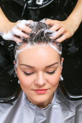 Hairdresser washing woman's hair in hairdresser salon