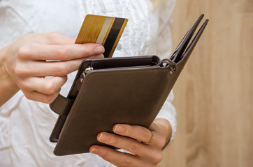 Woman hand pulls out or puts a credit card out of wallet