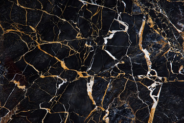 A beautiful pattern on the surface of a slab of black marble with yellow and white veins called New...