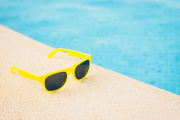 Concept of tourism and resort business - sunglasses and a swimming pool - time to book