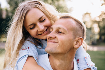 Fototapeta premium Happy couple on vacation. Lovers are laughing. Happy guy and girl. Lovers enjoy each other in the evening park.