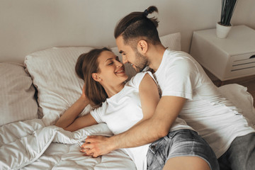 Beautiful loving couple kissing in bed	