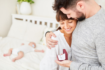 Heiratsantrag mit Baby im Hintergrund