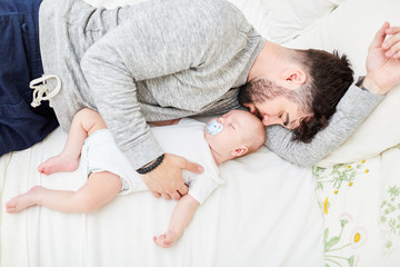Vater kuschelt sich an sein schlafendes Baby