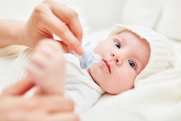 Erwachsener gibt Baby einen Schnuller