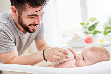 Vater in Elternzeit wäscht sein Baby