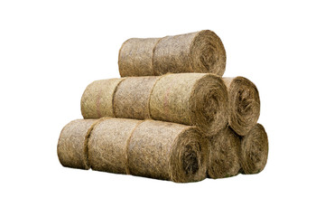 Stacked like a pyramid, bales of straw, tightened mesh . Feed and bedding for livestock on a dairy farm. General view.  Isolated photo .