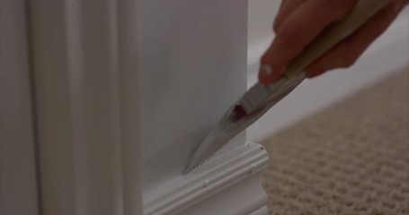 woman finishes painting room - close up on the last touch of the paintbrush