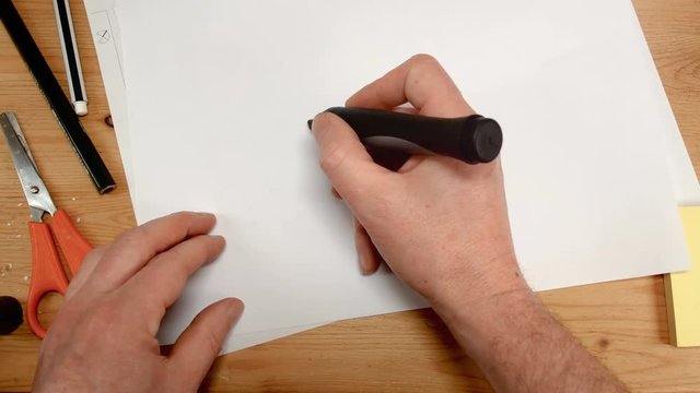 top view, an architect's hand draws the square base for a house, ideal footage for topics such as building renovation, design, new home and family