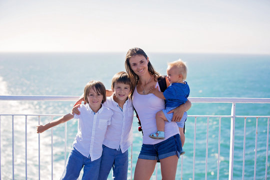 Happy Family With Children, Enjoying The Ship Trip From The Upper Deck Of The Ship