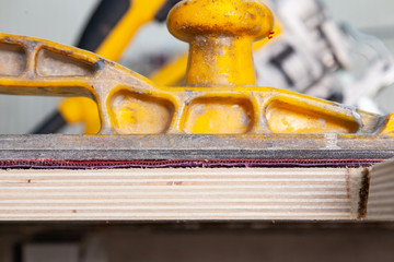 Yellow sandpaper and sandpaper purple color for processing wood and preparing the surface for painting in the construction workshop. Tool for industry and repair.