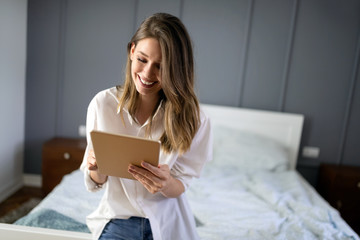Sexy young woman using tablet in bedroom