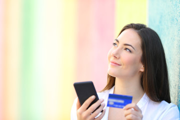 Fototapeta premium Happy online shopper thinking looking at side