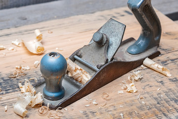 old hand tool plane, near plane wood chips the result of