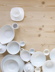 modern, white crockery, in different designs, stands on a light wooden background
