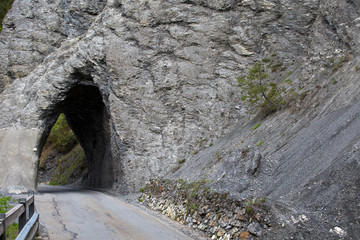 Strasse durch den Felsen. Tunnel in den Berge. Schmale und gefährliche Strasse.