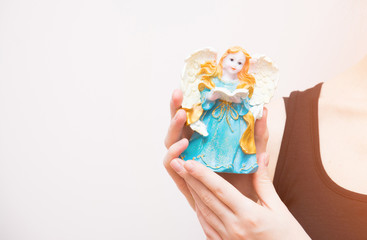 Fototapeta na wymiar Beautiful angel figurine woman hands hold