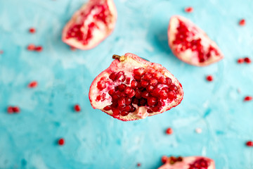 Half pomegranate fruit on blue background. Fresh red ripe