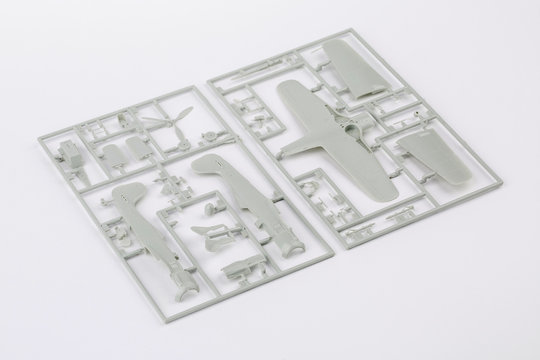 Kit For Assembling Gray Plastic Airplane Model On White Bsckground