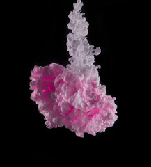 Coloured acrylic ink mixing in water on black