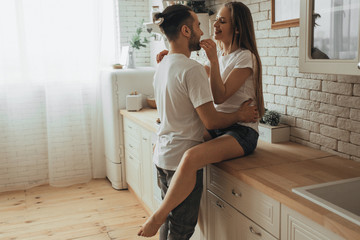 Beautiful loving couple kissing in kitchen
