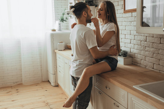 Beautiful loving couple kissing in kitchen