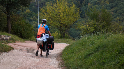 Obraz premium Tourists on bicycles in the mountains. Stunning rocky mountains in the background.