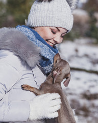 Woman playing with dog during winter