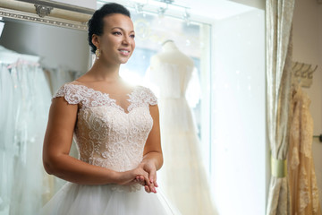 Beautifu bride choosing wedding dress in a wedding salon