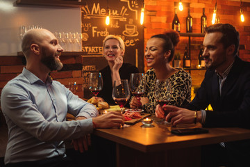 Group of friends having fun talk behind bar counter in a cafe