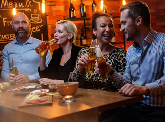 Group of friends having fun talk behind bar counter in a cafe