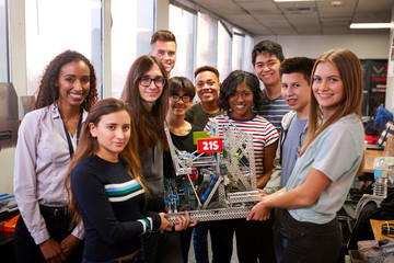 Portrait Of University Students With Teacher Holding Machine In Science Or Robotics Class