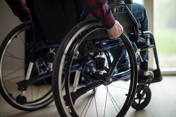 Close Up Of Man Sitting In Wheelchair At Home By Window