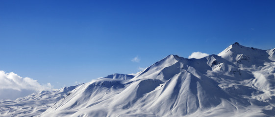 Fototapeta na wymiar Panoramic view on snowy sunlit mountains