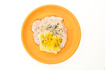 Half fired egg on orange plate