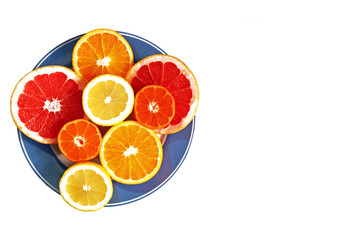 halved citrus fruits on a blue plate, isolated