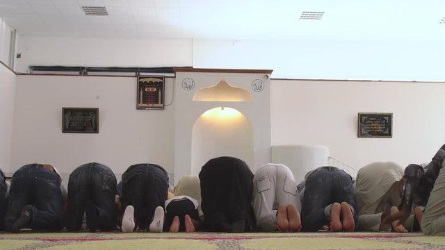 Muslims in the mosque who kneel to pray with a child