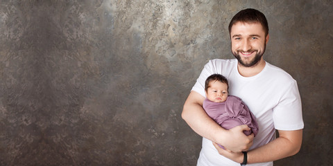 Smiling father holding his newborn baby  in  hands.Happy family concept. Copy space