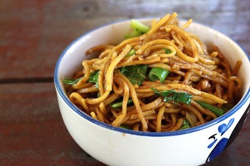 Stir-fried rice noodles in a ceramic cup placed on the table