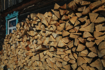 a stack of a large amount of wood under a canopy in the yard