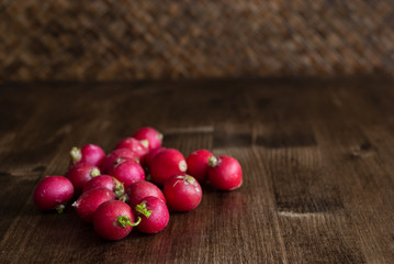 Horizontal close-up of radishes on braided wooden background