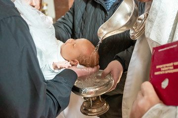Fototapeta Infant baptism. Baptism ceremony in Church. Water is poured on the head of an infant obraz