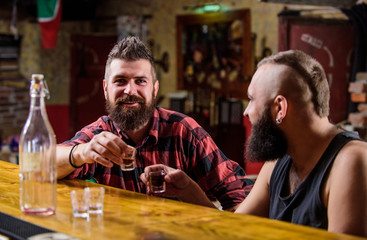 Strong alcohol drinks. Friday relaxation in bar. Friends relaxing in bar pub. Cheers concept. Lets get drunk. Hipster brutal bearded man spend leisure with friend at bar counter. Men relaxing at bar