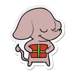 sticker of a cartoon smiling elephant with present