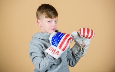 Fototapeta premium punching knockout. Fitness diet. energy health. Sport success. sportswear fashion. usa independence day. Happy child sportsman in boxing gloves. workout of small boy boxer. Feeling free and confident