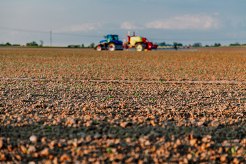 Agricultural worker with tractor working in field.